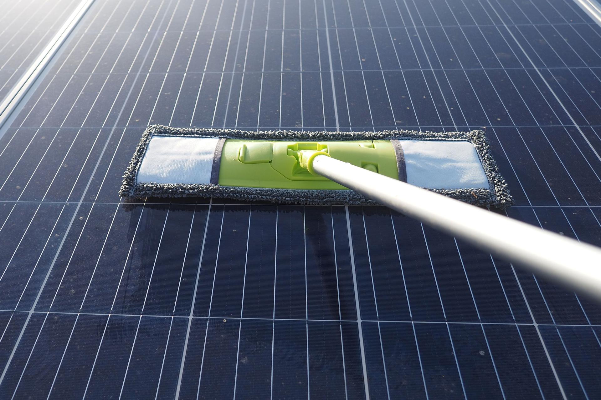 Cleaning solar panels to improve energy efficiency on a sunny day.